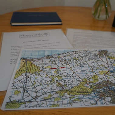 A local map and welcome pack laid out on the table — ready to guide your stay at Mossyards