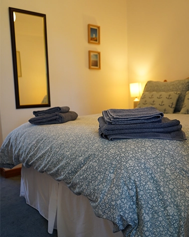 A cosy bedroom with fresh towels folded just for you — a calm retreat after a day of exploring